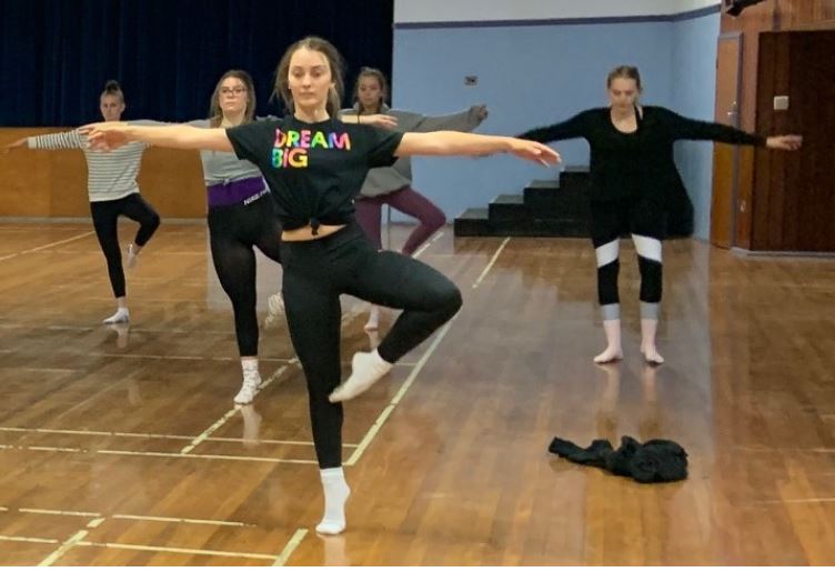Students in preparation for a pirouette during workshop in school hall