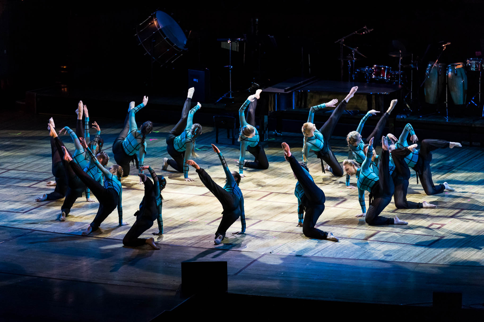 ensemble of dancers in circle formation on stage