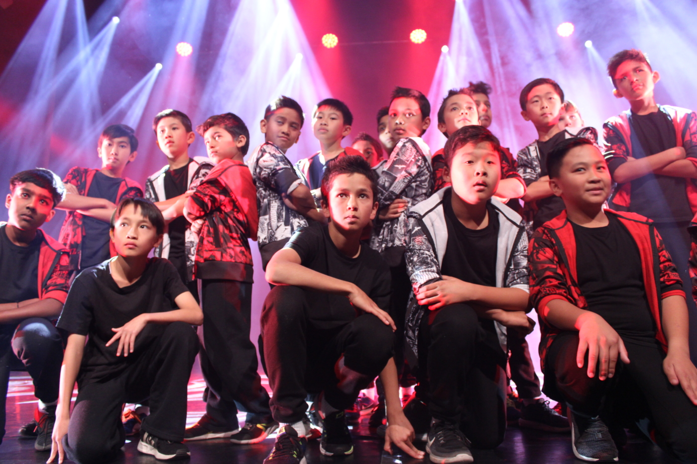 boys dance ensemble in finishing pose on stage at festival