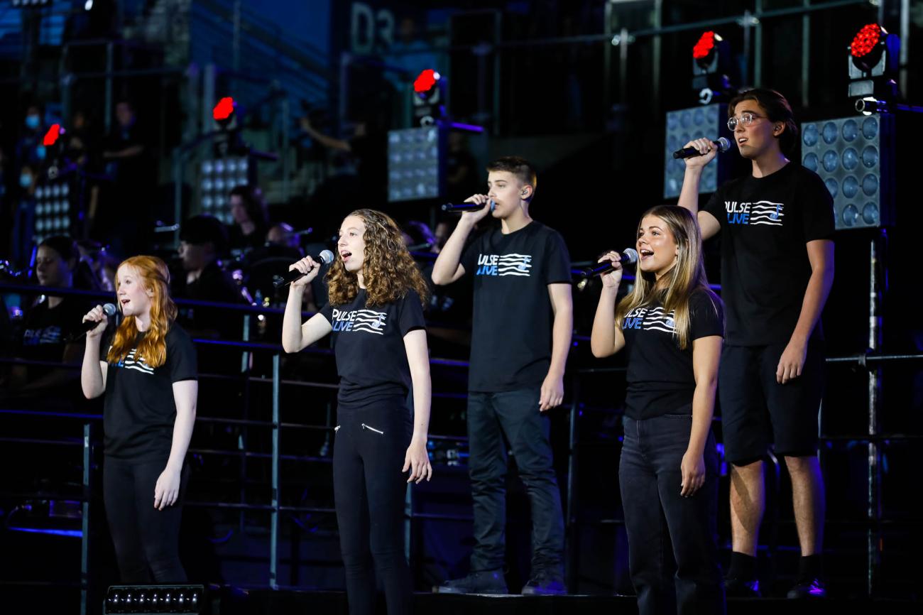 student vocalists on stage in black