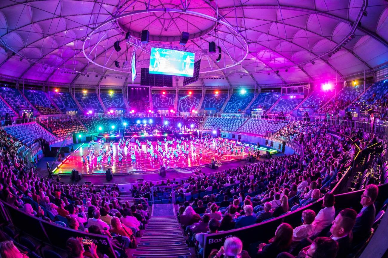 birds eye view of arena with dancers, choir and orchestra on stage