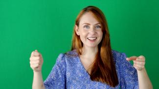 Charlotte Conner in front of a green screen.